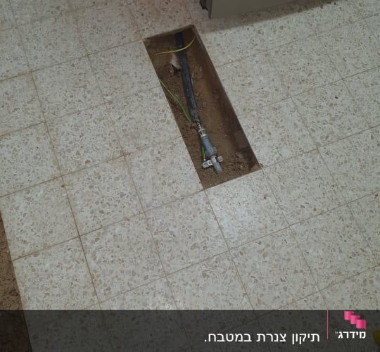 צינור מים חשוף ברצפה עם חיבורי אינסטלציה